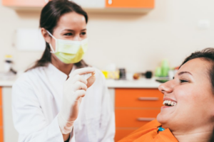 Dentist showing her patient her extracted tooth